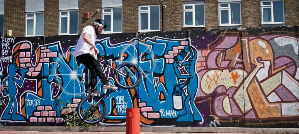 As you do this, you’ll be pulling the weight of the bike upwards with you, as it does this, you need to start pushing forward with your arms, moving the bars away from you.