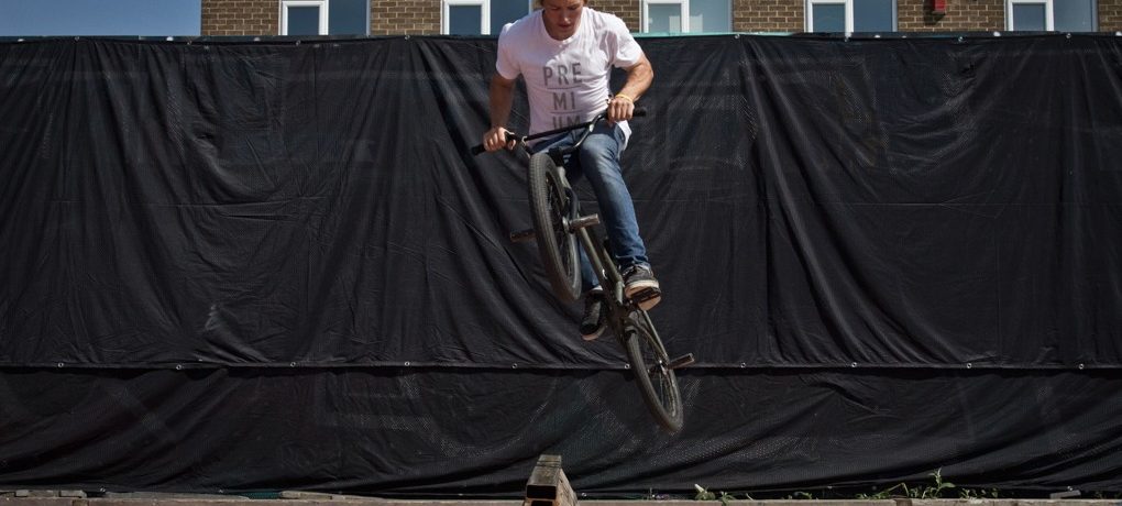 As the bike comes up and around, you need to start pushing forward on the bars, much like you would in a normal hop. This will tuck the bike up and level it out.