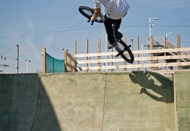 As you come up to the peak of your air, start levelling the bike out by pushing forward on the bars and bring your knees back and pinch the seat with them.