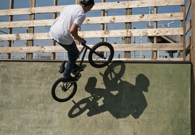 As the front end comes up to the top of the ramp, start turning and leaning the bike in towards the coping.