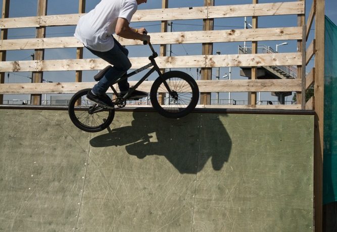 Keep your carve smooth and as the bike levels out, aim the pegs toward the coping. You shouldn’t need to do much more than just angle the bike in towards the deck, as you can see in the photo.