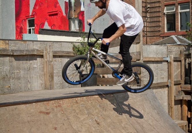 When your bike comes out of the top of the ramp, start shifting your weight forward and over the front end. Before you start taking your foot off, you can practise this by just popping out onto the deck and landing on your front wheel, parallel with the coping.