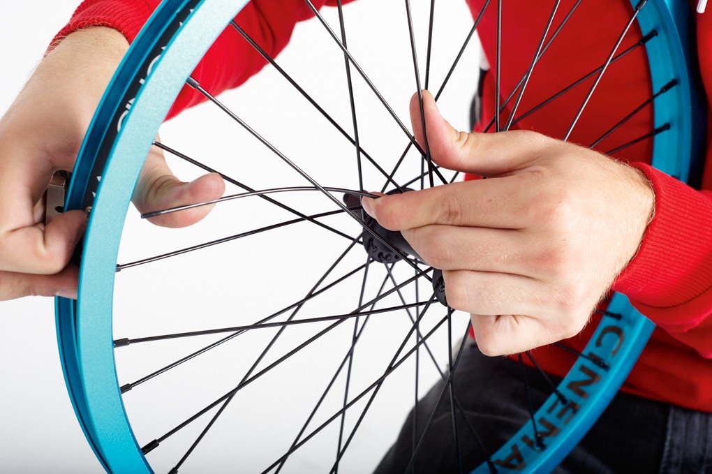 Next, you’ll need to make sure the spoke is laced through the wheel correctly. The wheel we’re using here is a standard laced 36 spoke wheel. By bending the new spoke, you need to fold it under the third spoke. The new spoke needs to cross over three spokes, going under the third. Outside spokes will go over two spokes then under the third and inside spokes
will go under two and over the third. Take a close look at the wheel and make sure you’re copying the pattern.